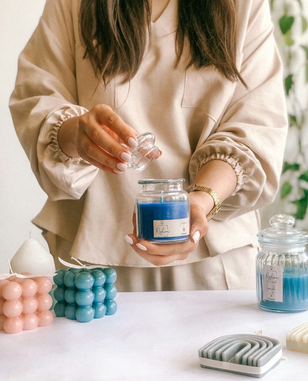 maker pouring warm soy wax into candle jars