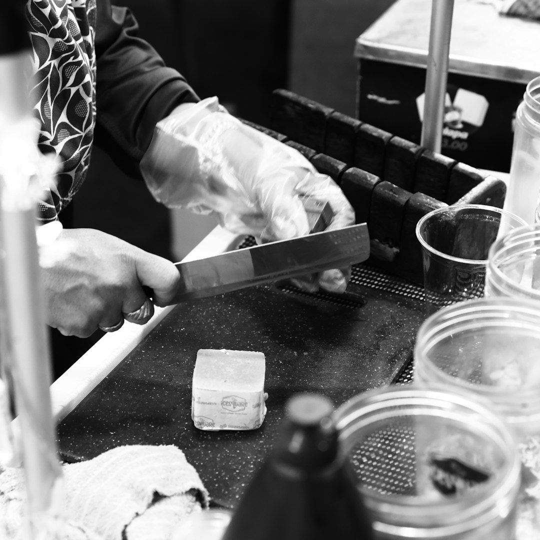 hands trimming cotton wicks on handmade candles