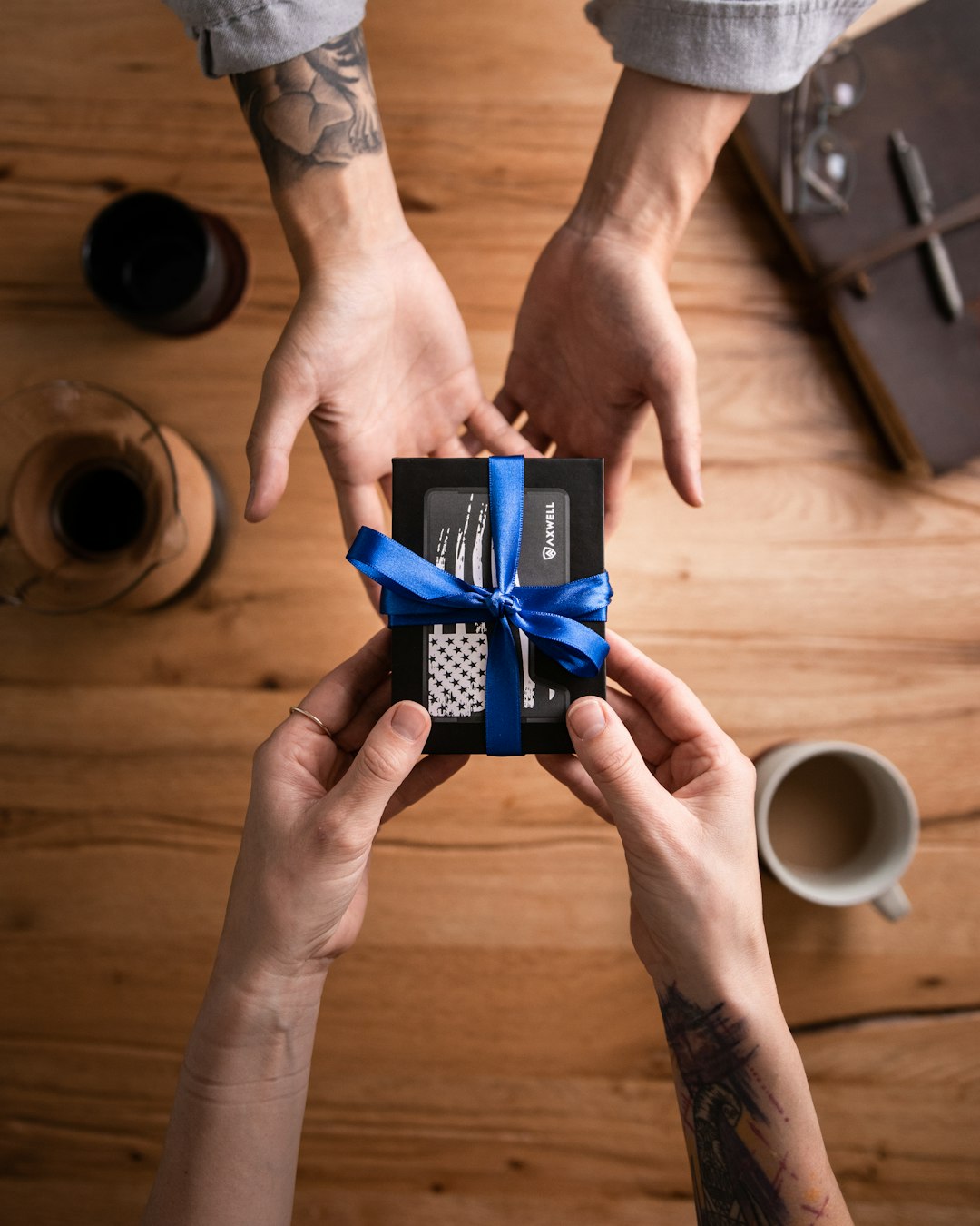 hands wrapping candle gift box with ribbon