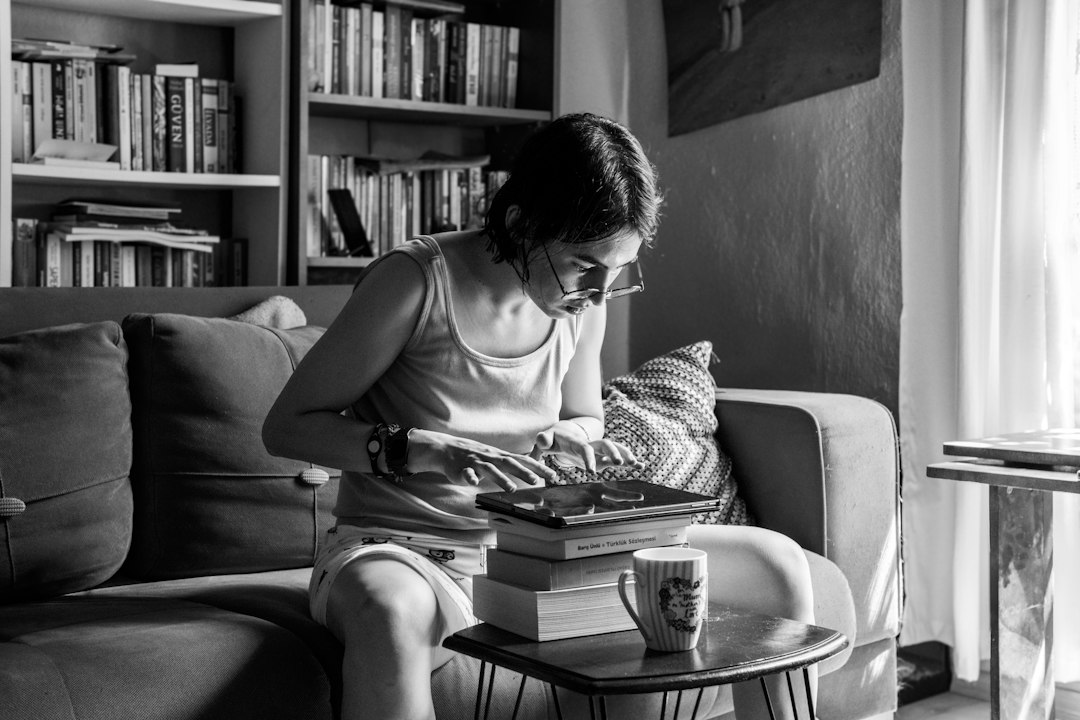 woman reading beside glowing candles at home